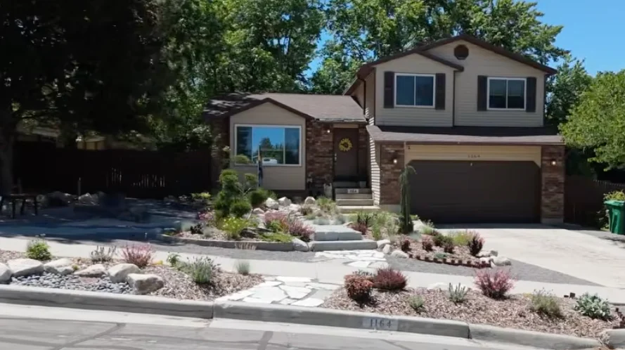 Sheldon and Kat’s completed front garden in Sandy, Utah, with stone paths, planted islands, and mature trees