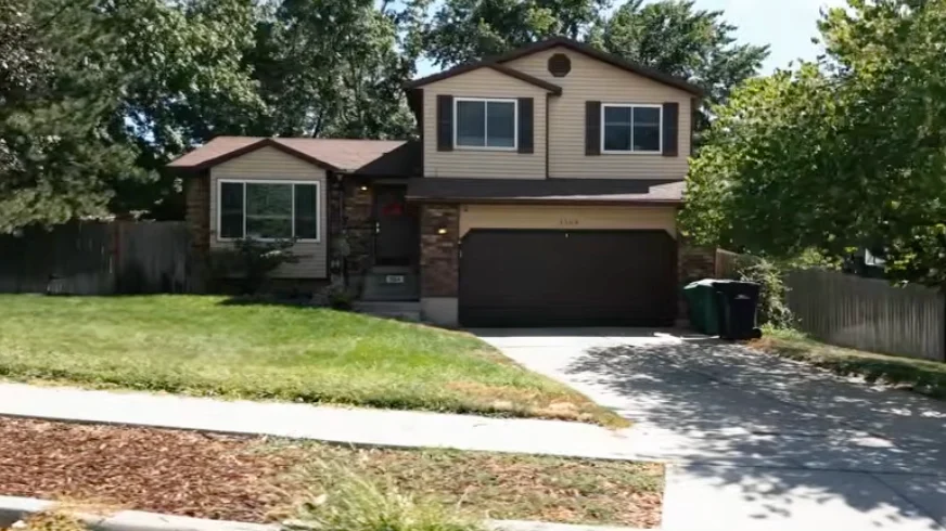 Before the project: a broad lawn between the sidewalk and the home, with established trees around the property
