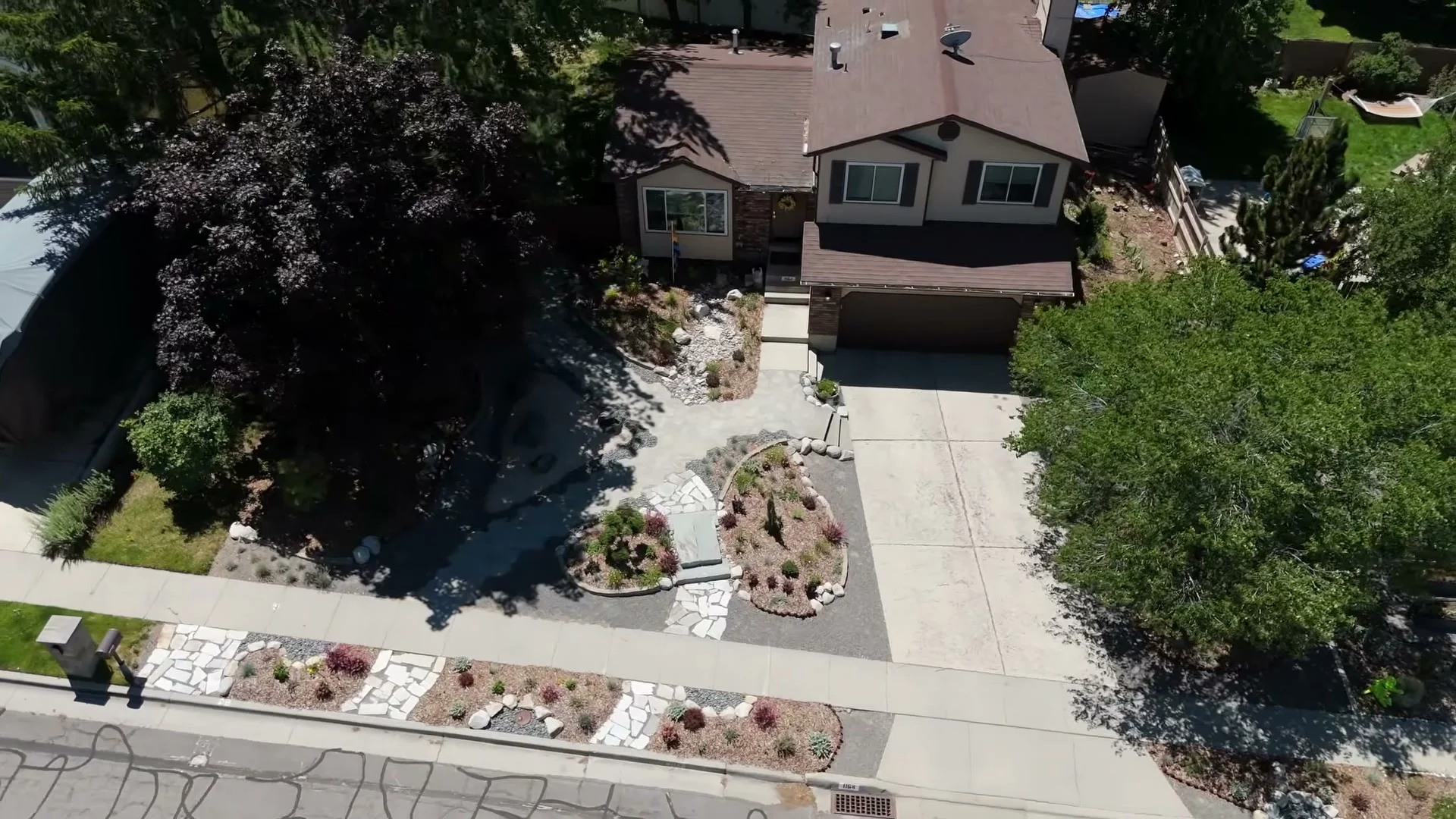 Aerial view of the completed garden, showing paths, planting islands, mature trees, and the landscaped park strip